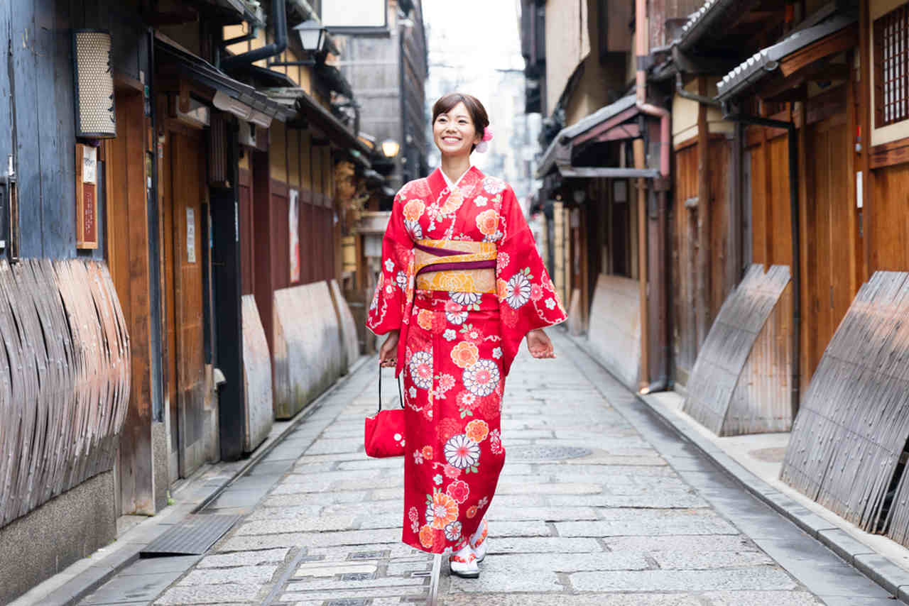 woman with red kimono walking on the street 