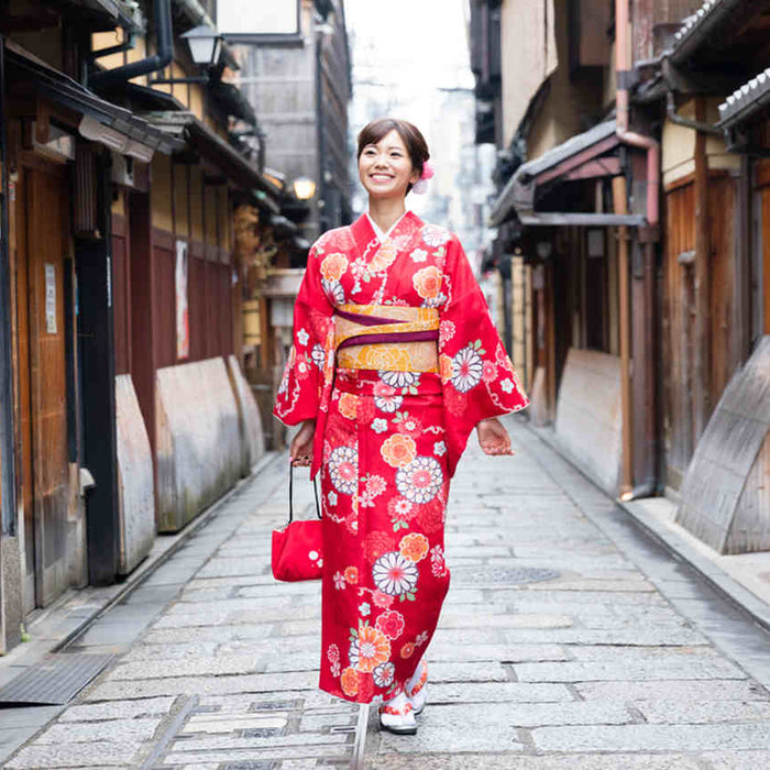 woman with red kimono walking on the street 